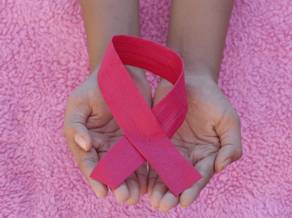 La réflexologie, ruban rose de lutte contre le cancer dans des mains d'enfants